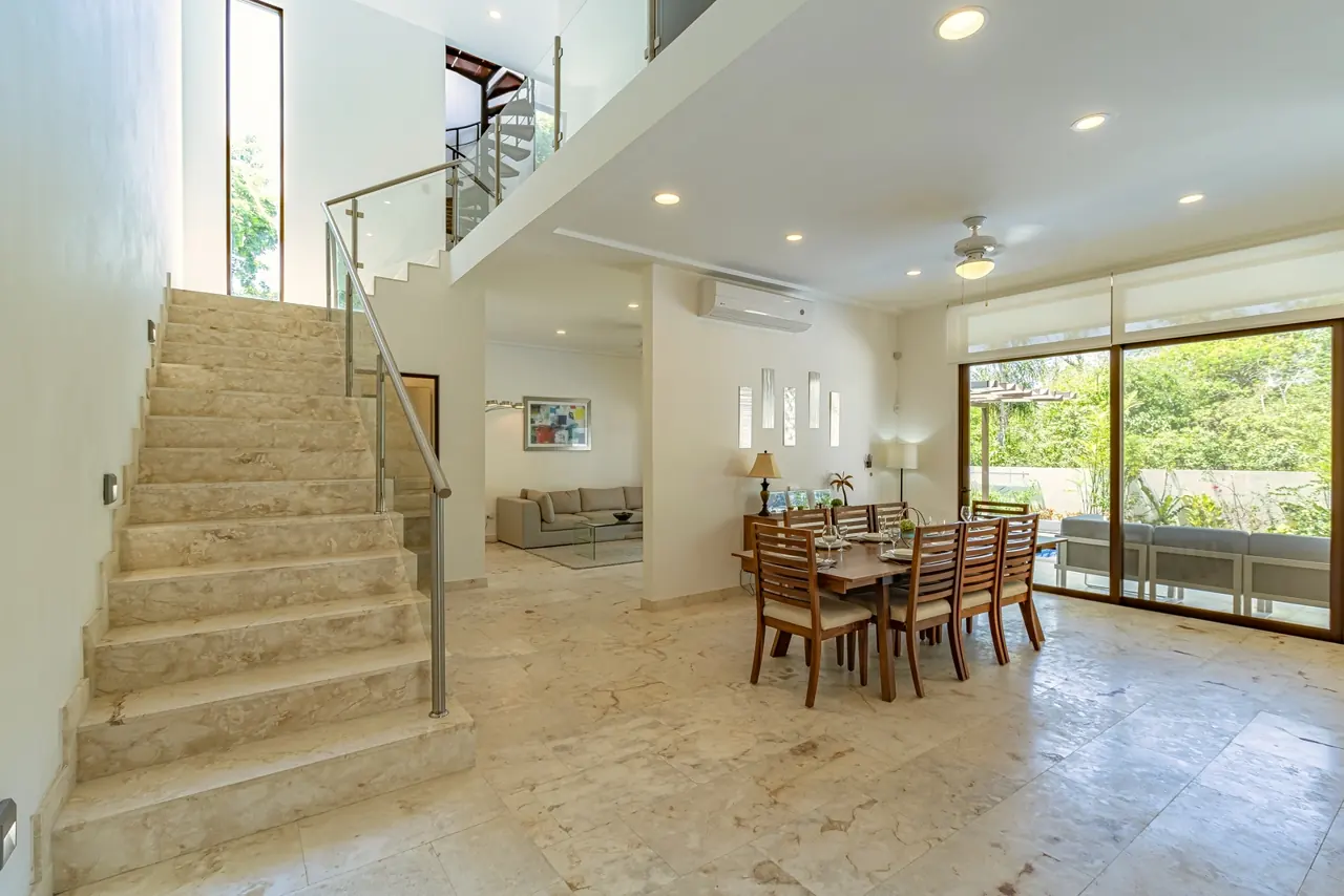Sala de doble altura con escalera y comedor